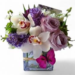 Bouquet of lavender roses and white orchids in a square glass vase