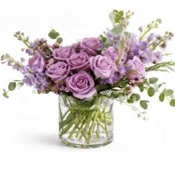 Lavender roses and purple flowers in a clear glass vase