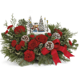 Red roses and carnations with a Christmas village centerpiece