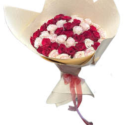 Bouquet of red and pale pink roses wrapped in beige paper