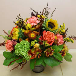 Mixed bouquet with sunflowers, roses, carnations, and chrysanthemums in a metal vase