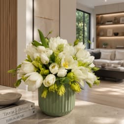 White tulips and green blooms arranged in a green vase