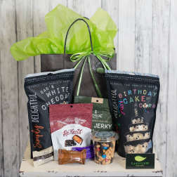 Gift bag filled with snack bags, candy, and a jar of mixed nuts