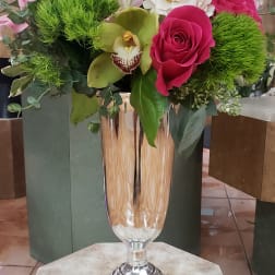 Mixed bouquet in a tall silver vase with pink, white, and green blooms