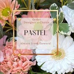 Pastel flowers with daisies and carnations behind a designer's choice label