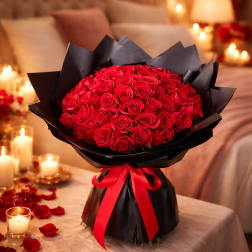 Bouquet of red roses wrapped in black paper with a red ribbon