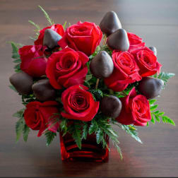 Red roses with chocolate-covered strawberries in a red vase