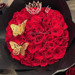 Round bouquet of red roses with a tiara and gold butterfly decorations