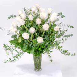 Tall bouquet of white roses in a clear glass vase