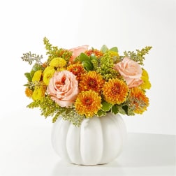Pink roses and yellow-orange mums in a white pumpkin vase