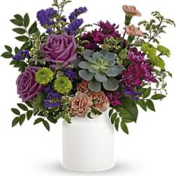 Purple and pink floral arrangement in a white vase