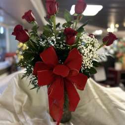 Red roses in a vase with a large red ribbon