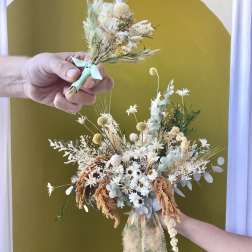 Dried flower bouquet with white and pale blue blooms tied with ribbon