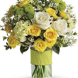 Bouquet of yellow and white roses with green mums in a glass vase