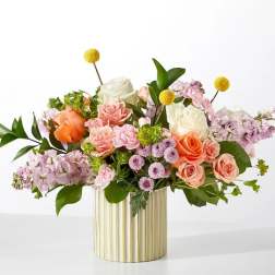 Mixed bouquet of roses and pastel flowers in a gold ribbed vase