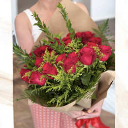 Bouquet of red roses wrapped in brown paper