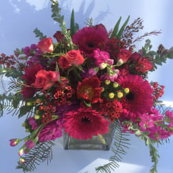Pink and red mixed bouquet in a clear square vase