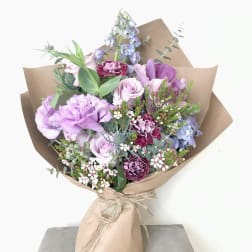 Lavender and pink mixed bouquet wrapped in brown paper