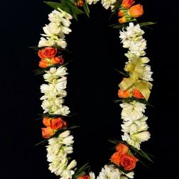 Orange roses and white flowers arranged in a floral garland