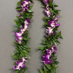 Purple orchid lei with green leaves laid on a gray surface