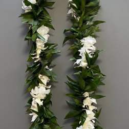 White flower lei with dense green leaves on a gray background