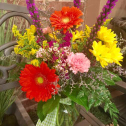 Colorful mixed bouquet in a glass vase with gerbera daisies and carnations