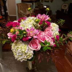 Pink roses and hydrangeas in a glass vase with magenta blooms