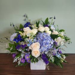 Blue and white floral arrangement in a white vase