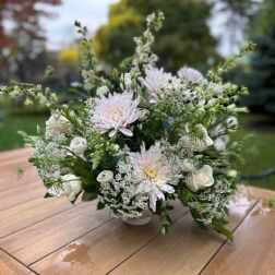 White and pale pink floral arrangement in a low vase