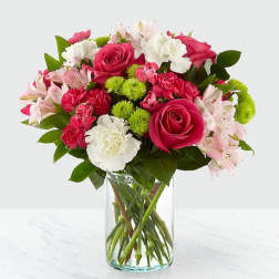 Bouquet of pink roses, carnations, and alstroemeria in a clear glass vase