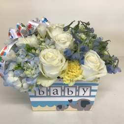 White roses and blue flowers in a baby-themed box with elephant graphics