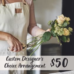 Florist holding a small bouquet of pale roses and greenery