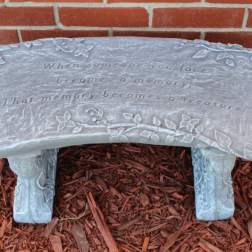 Decorative memorial bench with an engraved quote and floral vine details