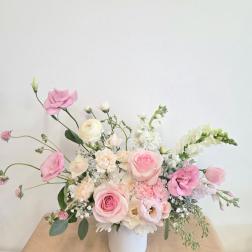 Pink and white floral arrangement in a white vase