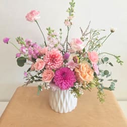 Pink and peach mixed flower arrangement in a white vase