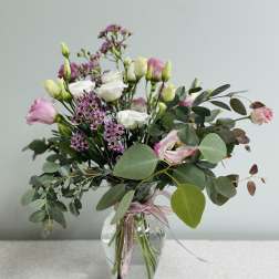Pink and white bouquet in a clear glass vase with eucalyptus