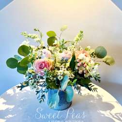 Pink roses and white blossoms arranged in a blue vase