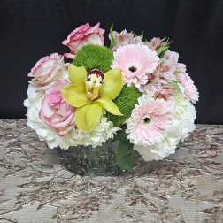 Pink roses and gerbera daisies with a yellow orchid in a low vase