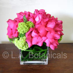 Pink rose bouquet with green hydrangea in a clear square vase