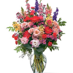 Mixed bouquet of colorful flowers in a clear glass vase