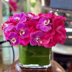 Pink roses and purple orchids in a glass vase