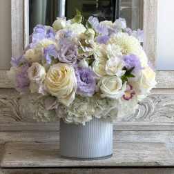 Pastel bouquet of white and lavender flowers in a ribbed vase