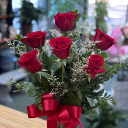 Bouquet of red roses with white filler and a red ribbon