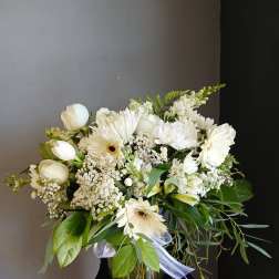 White mixed bouquet in a glass vase with gerbera daisies and tulips