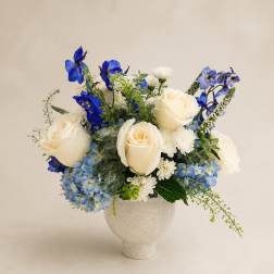 Blue and white floral arrangement in a white vase