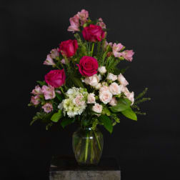 Pink roses and pale alstroemeria in a clear glass vase
