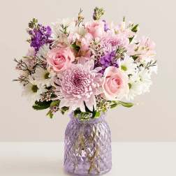 Pink and white mixed bouquet in a purple glass vase