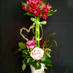 Pink and white roses in a white pot with a tall pink flower cluster