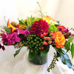 Bright mixed bouquet in a glass vase with orange, pink, and yellow blooms