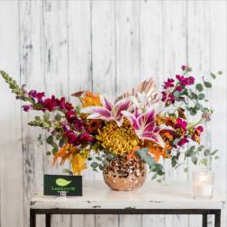 Bouquet of pink lilies and magenta flowers in a copper vase